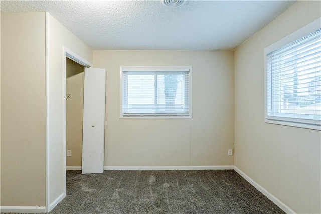 unfurnished bedroom with baseboards, a textured ceiling, and carpet