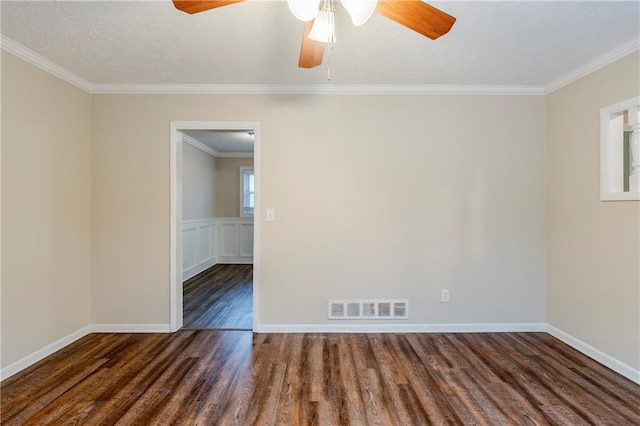 spare room featuring visible vents, a textured ceiling, wood finished floors, crown molding, and ceiling fan