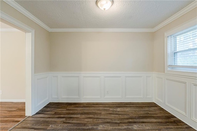 empty room with a wainscoted wall, a textured ceiling, dark wood finished floors, and crown molding