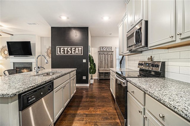 7086 Gladstone Cir, Lithonia, GA 30038 - kitchen featuring stainless steel appliances, dark wood-style flooring, tasteful backsplash, light stone countertops, and recessed lighting