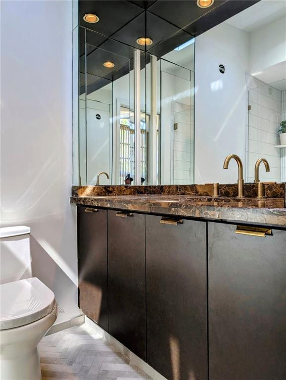 bathroom with toilet, a shower stall, and vanity