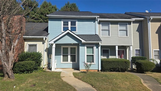 multi unit property featuring a front yard and roof with shingles