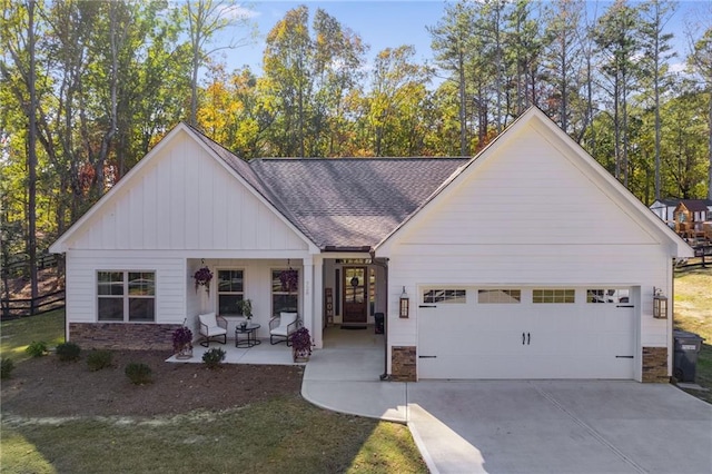 view of front facade featuring a porch, a garage, and a front yard