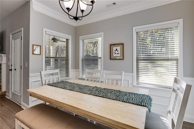 dining area with an inviting chandelier, hardwood / wood-style floors, and crown molding