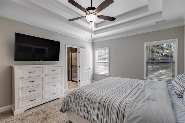 carpeted bedroom featuring ensuite bath, a raised ceiling, and ceiling fan