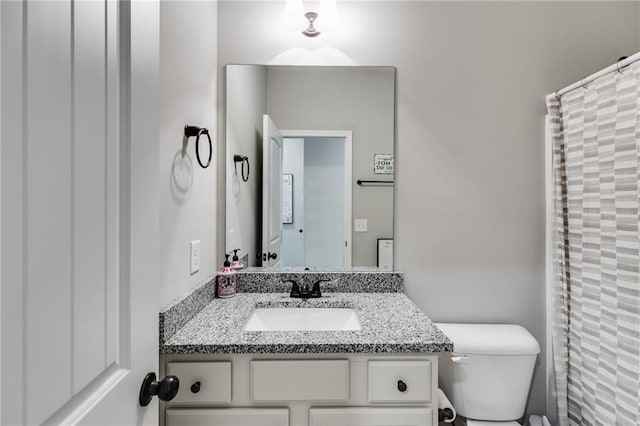 bathroom featuring walk in shower, vanity, and toilet