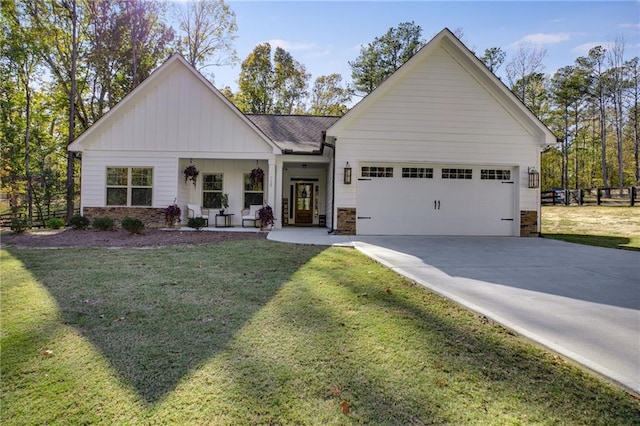 view of front of home featuring a garage, a front yard, and a porch