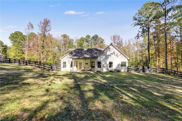 rear view of property with a yard and a patio area