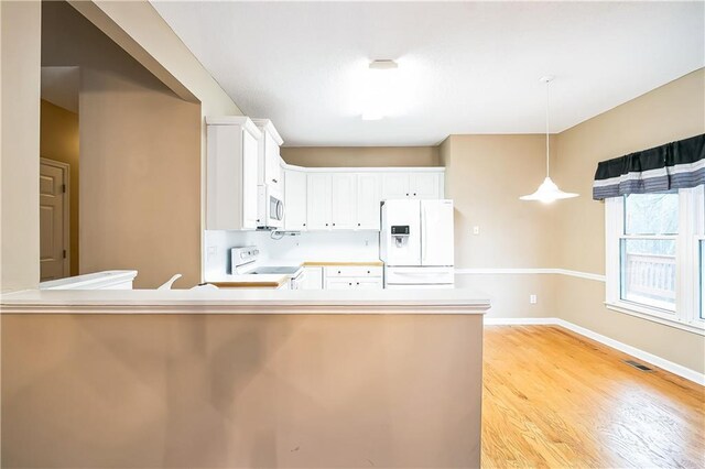 1008 Walnut Creek Dr, Woodstock, GA 30188 - kitchen featuring visible vents, white appliances, light wood-type flooring, white cabinetry, and hanging light fixtures