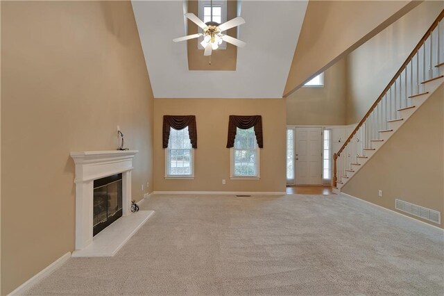 1008 Walnut Creek Dr, Woodstock, GA 30188 - unfurnished living room with ceiling fan, high vaulted ceiling, a glass covered fireplace, carpet, and visible vents