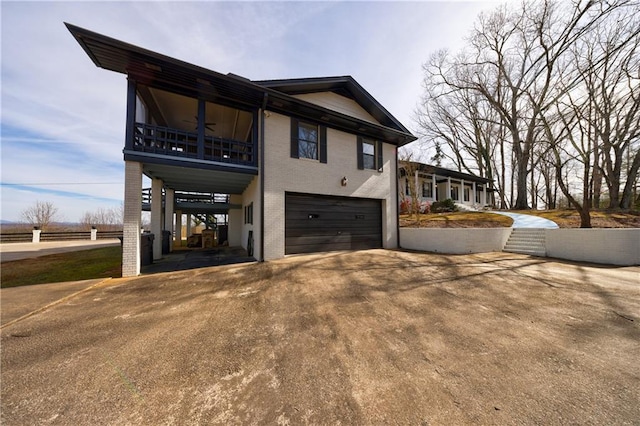 2316 Mountain Crest Pl, Gainesville, GA 30501 - view of side of home featuring a garage, asphalt driveway, a ceiling fan, brick siding, and a balcony