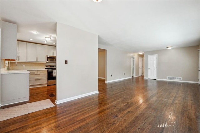 unfurnished living room with dark wood-type flooring and sink