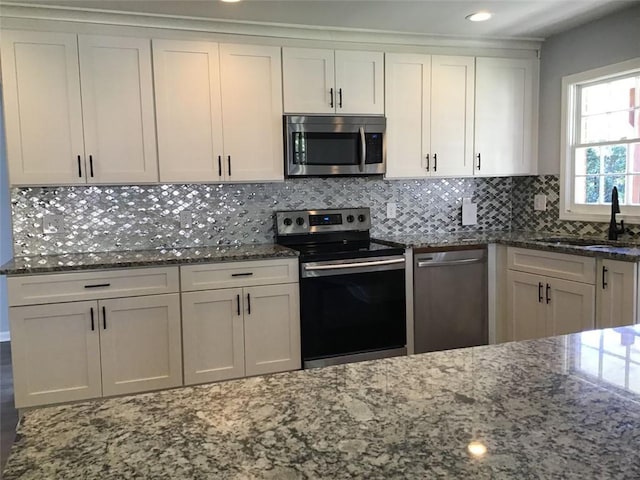 kitchen featuring white cabinetry, backsplash, stainless steel appliances, and sink