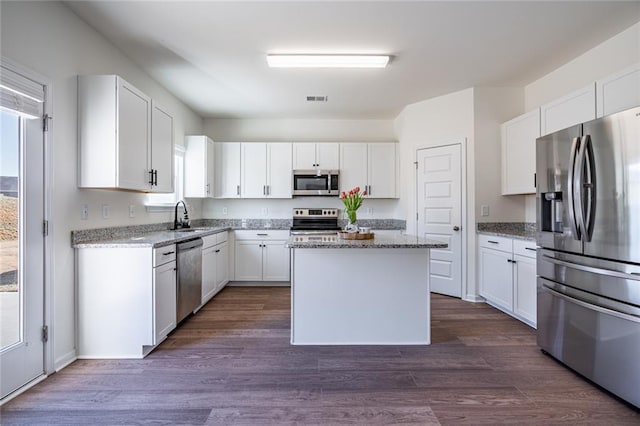 1628 Newport Dr, Bethlehem, GA 30620 - kitchen featuring stainless steel appliances, a sink, white cabinets, a kitchen island, and light stone counters