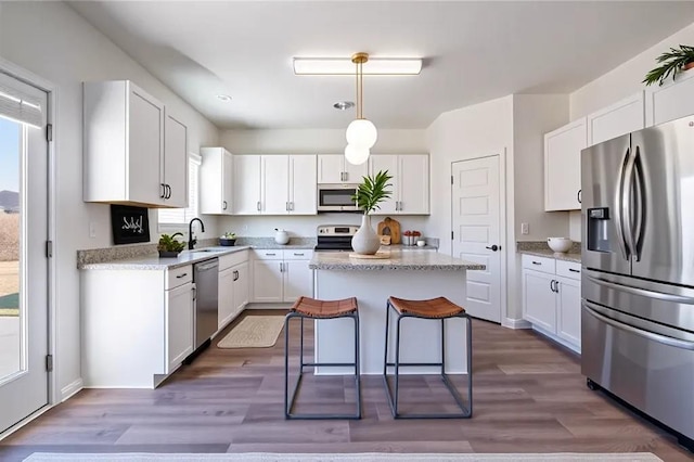 1628 Newport Dr, Bethlehem, GA 30620 - kitchen with appliances with stainless steel finishes, a sink, a center island, white cabinetry, and wood finished floors