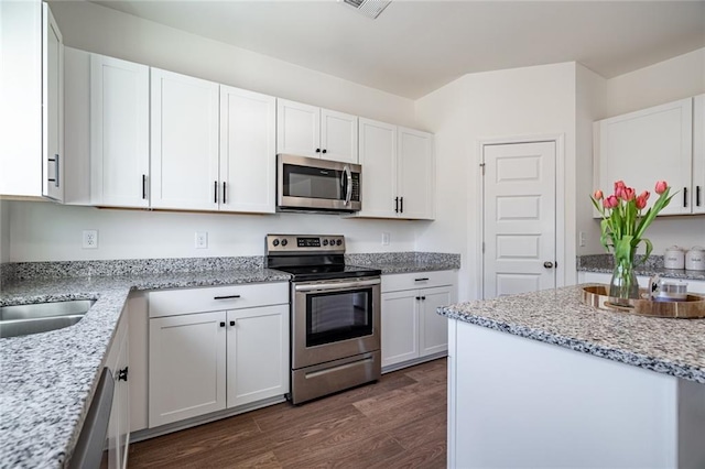 1628 Newport Dr, Bethlehem, GA 30620 - kitchen featuring stainless steel appliances, dark wood-style flooring, white cabinets, and light stone counters