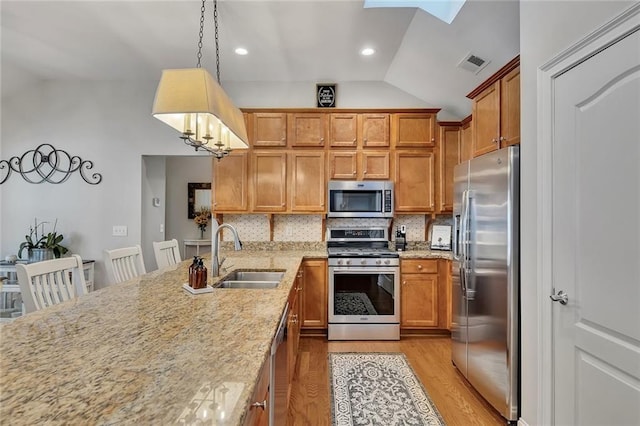 kitchen with stainless steel appliances, backsplash, a sink, and visible vents