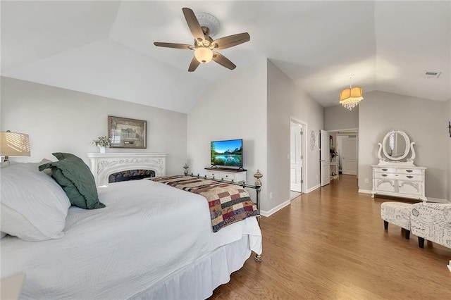 bedroom featuring lofted ceiling, wood finished floors, a ceiling fan, visible vents, and baseboards