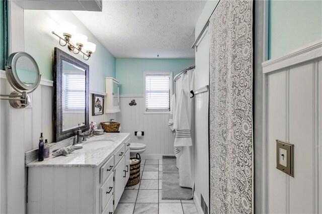 1189 Norfolk Dr NW, Acworth, GA 30102 - full bathroom with vanity, toilet, a wainscoted wall, marble finish floor, and a textured ceiling