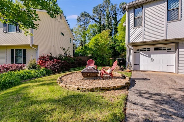 1189 Norfolk Dr NW, Acworth, GA 30102 - view of yard featuring driveway, an attached garage, fence, and an outdoor fire pit