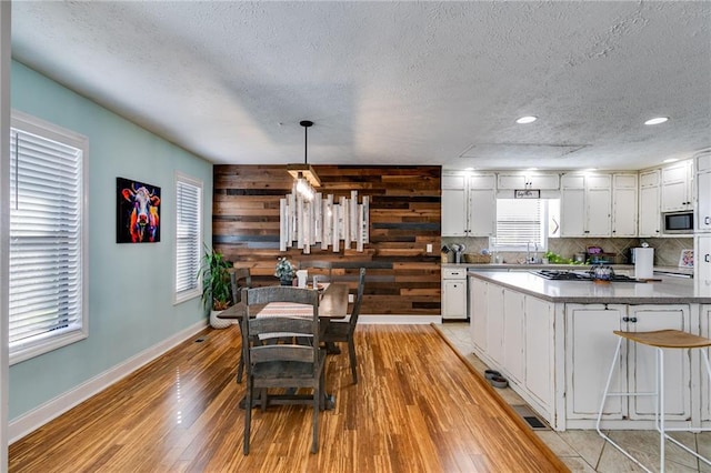 1189 Norfolk Dr NW, Acworth, GA 30102 - kitchen featuring white cabinetry, baseboards, light wood finished floors, and stainless steel microwave