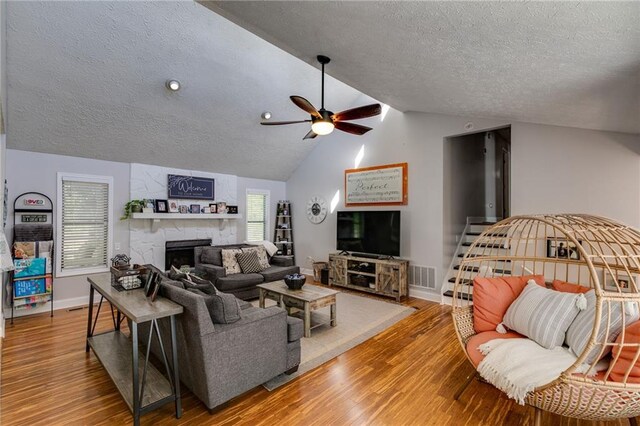 1189 Norfolk Dr NW, Acworth, GA 30102 - living area featuring visible vents, a large fireplace, a textured ceiling, and ceiling fan