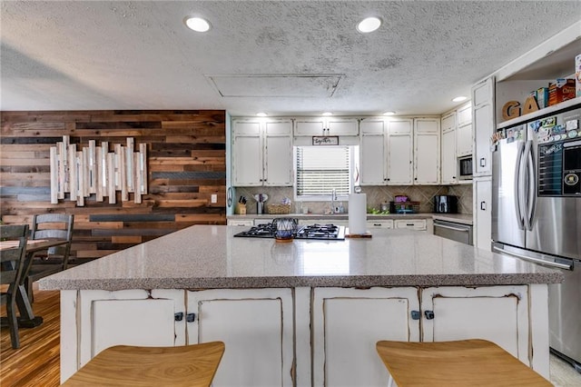 1189 Norfolk Dr NW, Acworth, GA 30102 - kitchen featuring stainless steel appliances, a large island, tasteful backsplash, white cabinetry, and a textured ceiling