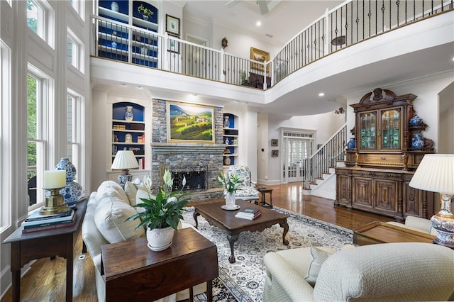 2630 Weddington Pl NE, Marietta, GA 30068 - living area with a high ceiling, wood finished floors, a stone fireplace, crown molding, and baseboards