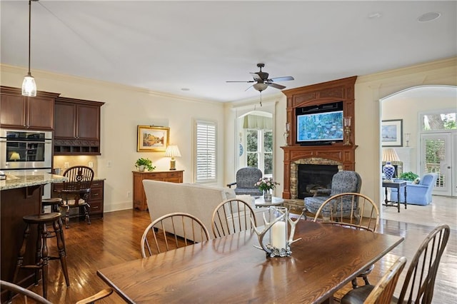 2630 Weddington Pl NE, Marietta, GA 30068 - dining space featuring ceiling fan, ornamental molding, a fireplace, baseboards, and dark wood-type flooring