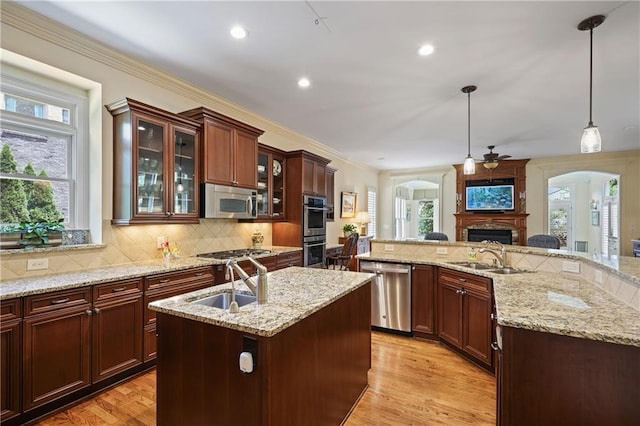 2630 Weddington Pl NE, Marietta, GA 30068 - kitchen featuring appliances with stainless steel finishes, a sink, a fireplace, ceiling fan, and ornamental molding