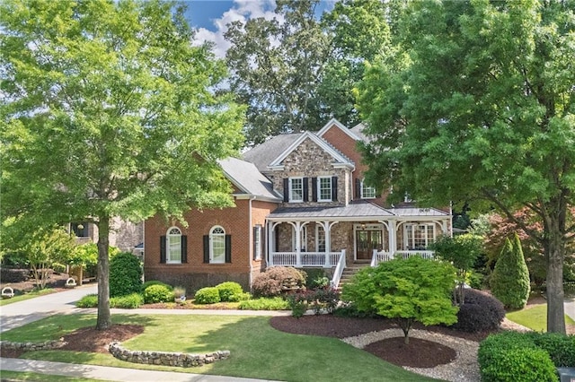 2630 Weddington Pl NE, Marietta, GA 30068 - view of front facade featuring covered porch, a front lawn, stone siding, and brick siding