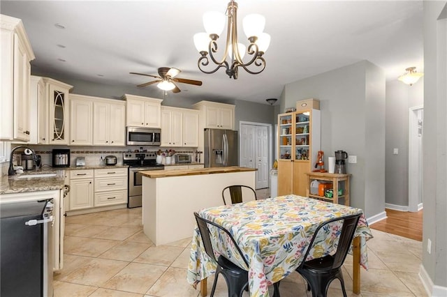 1019 Legacy Walk, Woodstock, GA 30189 - kitchen with appliances with stainless steel finishes, a sink, wood counters, a center island, and backsplash