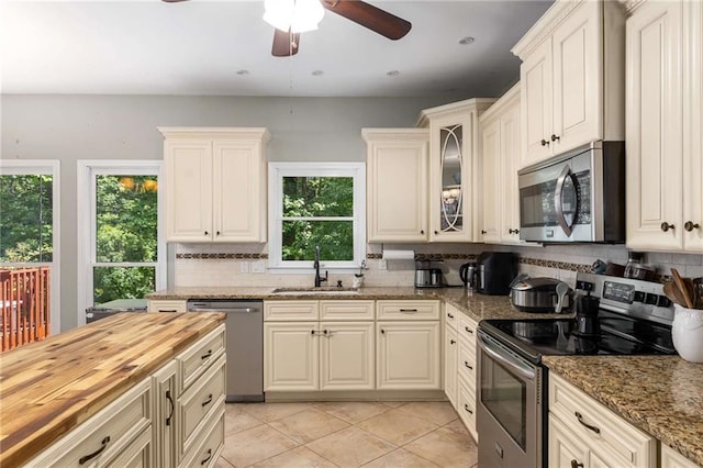 1019 Legacy Walk, Woodstock, GA 30189 - kitchen featuring stainless steel appliances, a sink, butcher block countertops, and tasteful backsplash