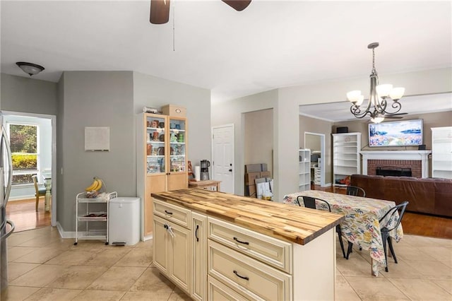 1019 Legacy Walk, Woodstock, GA 30189 - kitchen with cream cabinetry, wooden counters, light tile patterned flooring, a ceiling fan, and a chandelier