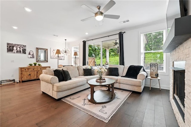 living area with a ceiling fan, a fireplace, dark wood-style floors, baseboards, and recessed lighting