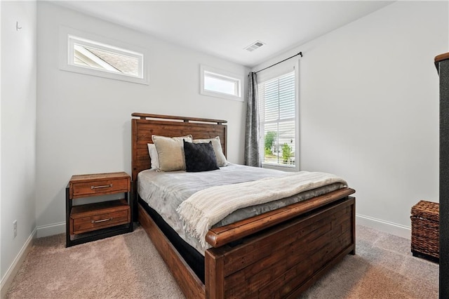 bedroom with light colored carpet and baseboards
