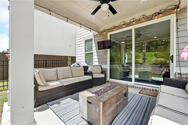 view of patio with ceiling fan, fence, and an outdoor living space with a fire pit