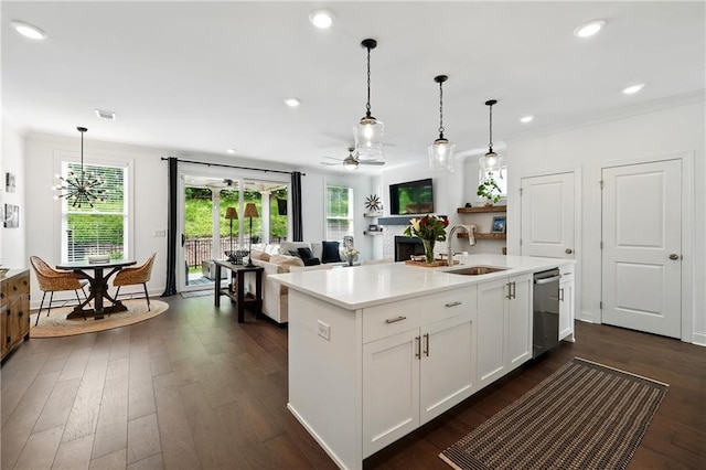 kitchen with a sink, dishwasher, dark wood finished floors, light countertops, and pendant lighting