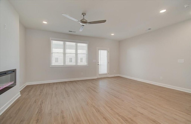 unfurnished living room with ceiling fan and light hardwood / wood-style floors