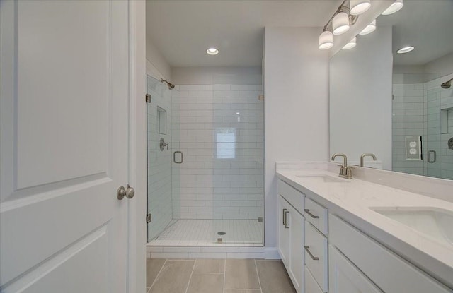 bathroom featuring walk in shower, vanity, and tile patterned flooring