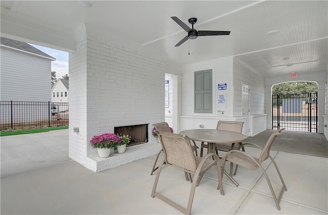 view of patio / terrace featuring an outdoor brick fireplace and ceiling fan