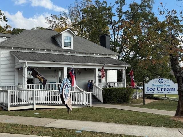 view of front of house featuring covered porch and a front lawn