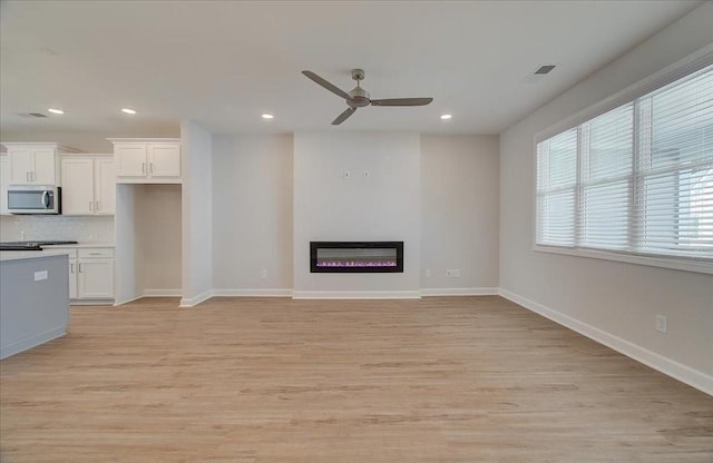 unfurnished living room with light hardwood / wood-style floors and ceiling fan