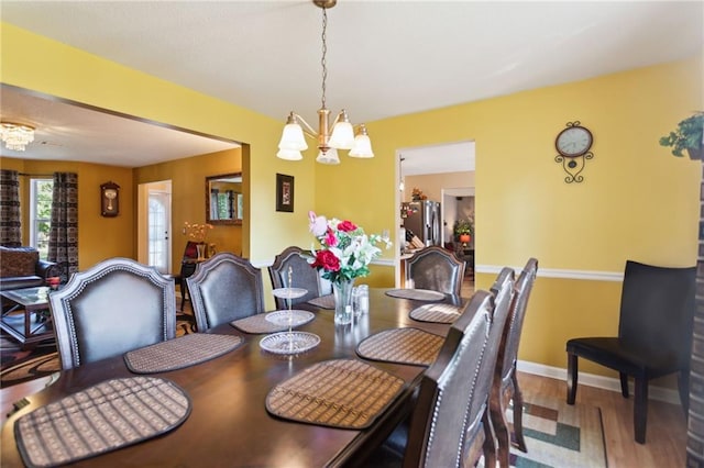 dining area with a chandelier and wood-type flooring