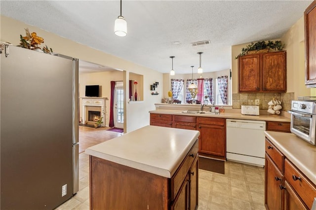 4450 Millenium View Ct, Snellville, GA 30039 - kitchen with white dishwasher, freestanding refrigerator, brown cabinets, light countertops, and a textured ceiling