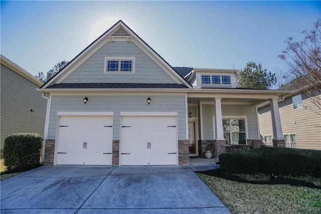 craftsman house with a garage, concrete driveway, a porch, and stone siding