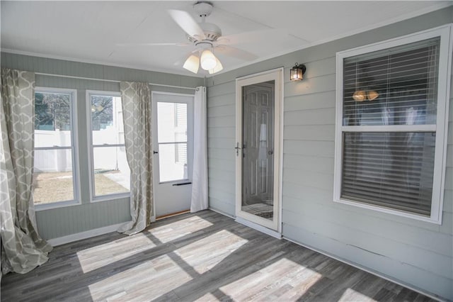 unfurnished sunroom featuring a ceiling fan