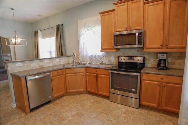 kitchen featuring appliances with stainless steel finishes, a sink, and decorative backsplash