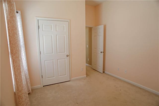 unfurnished bedroom featuring baseboards and light colored carpet