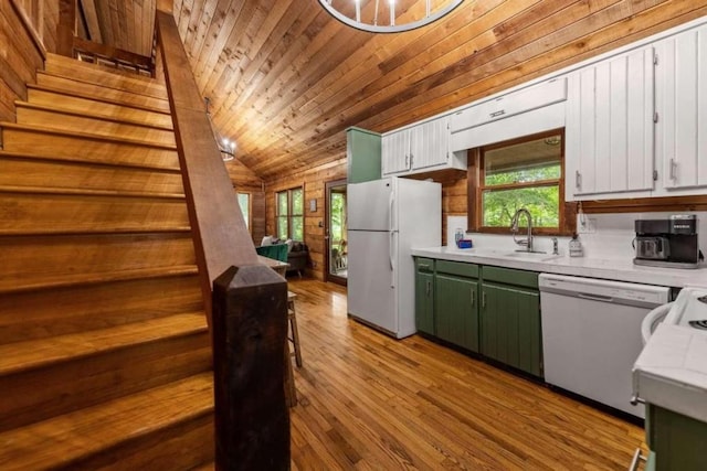 kitchen with wooden ceiling, white appliances, sink, wooden walls, and green cabinetry